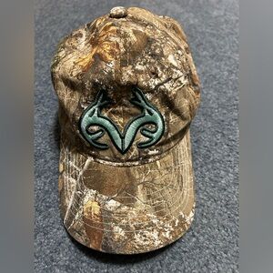 Camo Realtree hat with teal embroidered deer antlers.